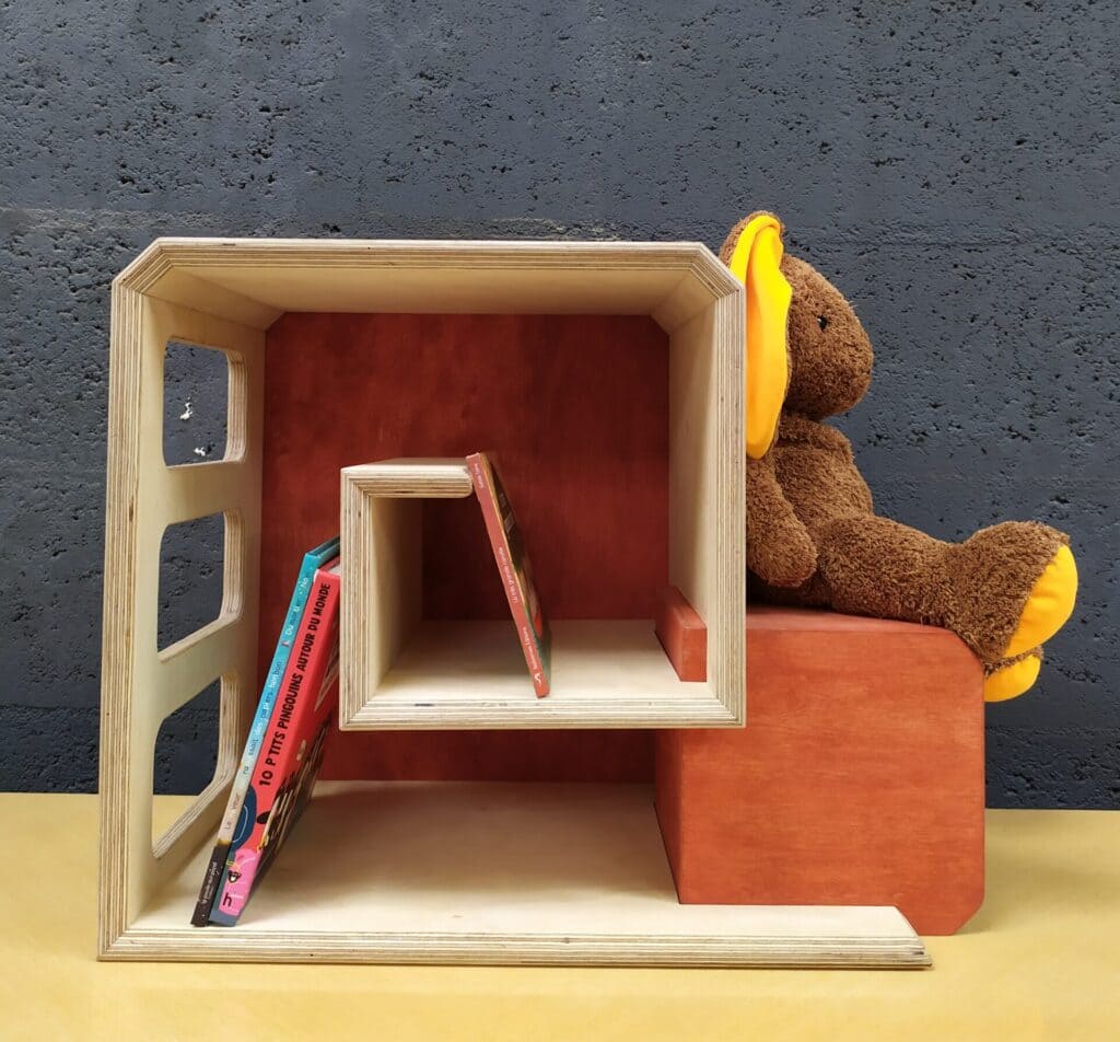 Escarbeau rouge brique mis en scène pour illustrer la fonction de rangement (bibliothèque) et d'assise sur la tête